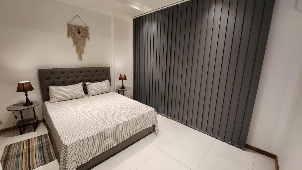 a bedroom with a bed and a large window at SEAVIEW LUXURY APPARTMENT in Flic-en-Flac