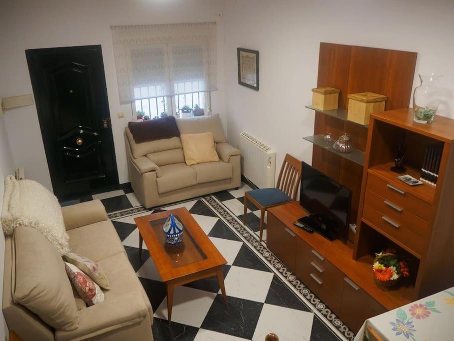 sala de estar con sofá y TV en LA CASA DE SENSI en Güéjar-Sierra