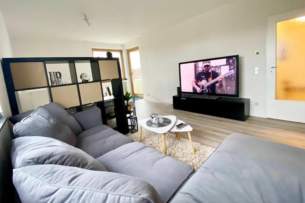 a living room with a couch and a flat screen tv at 2-room apartment with balcony in Meckenheim