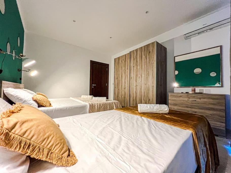 Habitación de hotel con 2 camas y TV en Wenza's Nest 5 min walk from St Julians en San Ġwann