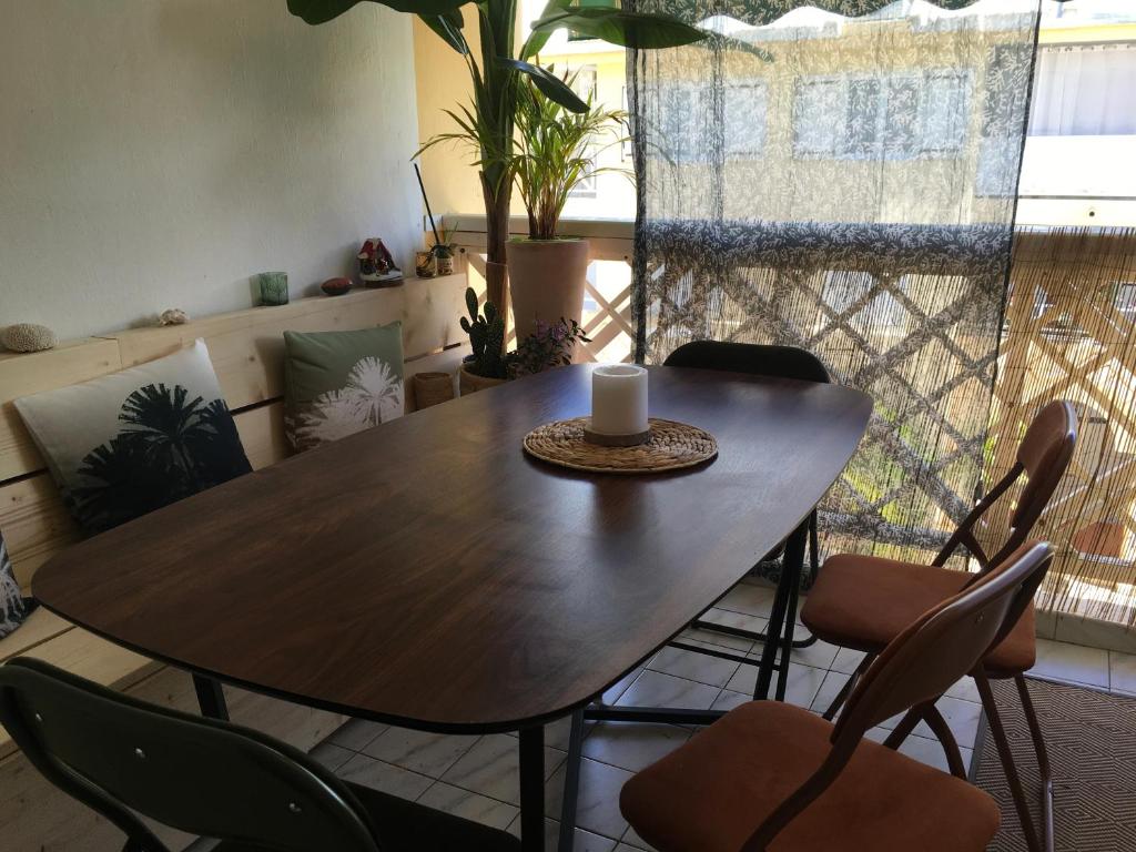 - une table à manger avec des chaises et une bougie dans l'établissement Le Bois Saint Martin, à Filaos