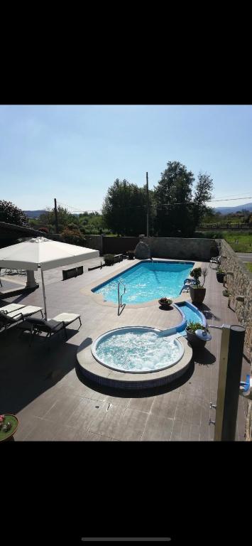 a large swimming pool with a table and chairs at A casa da charca in Valga