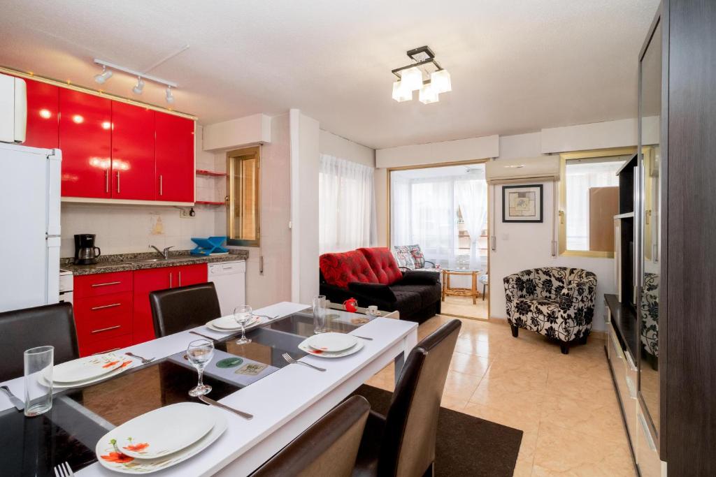 eine Küche und ein Wohnzimmer mit roten Schränken in der Unterkunft Espanatour AMARION in Torrevieja