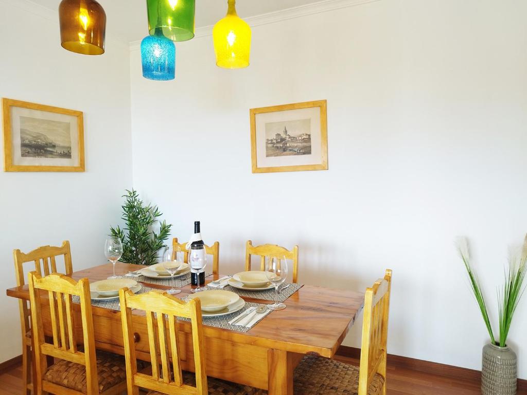 Un comedor con mesa y sillas de madera. en MCStylo - Varandas Falésia, en Caniço