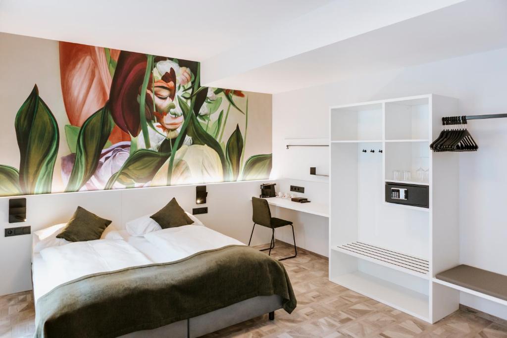 un dormitorio con una cama y una pintura de una mujer en ART-INN Design Self-Check-in-Hotel, en Linz