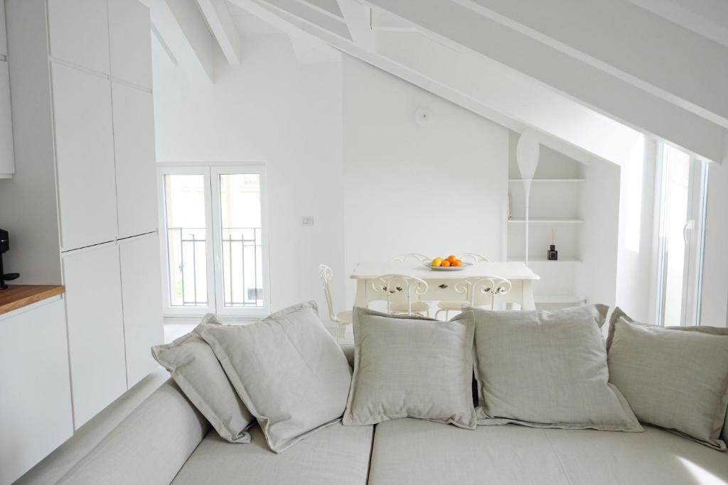 Biały salon z kanapą z poduszkami w obiekcie La Maison City Life Apartments w Mediolanie