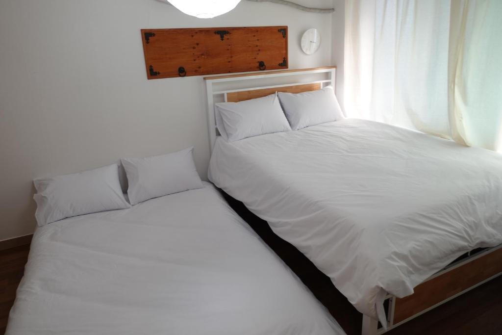 a bedroom with two beds and a window at Hostel JL in Chung-jeong in Seoul