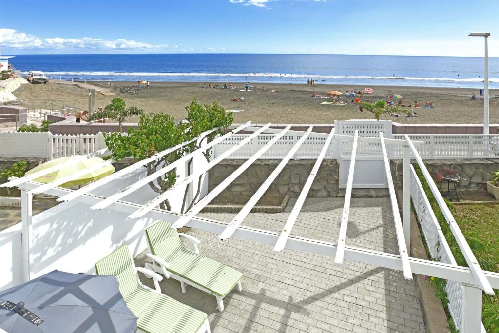 einen Balkon mit 2 Stühlen und einem Strand in der Unterkunft Mare Nostrum in Maspalomas