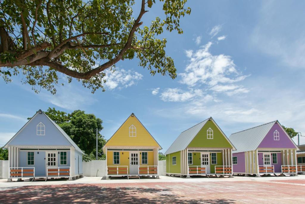 una fila di case dipinte in colori diversi di Rainbow Huts by Zing Motel a Butterworth