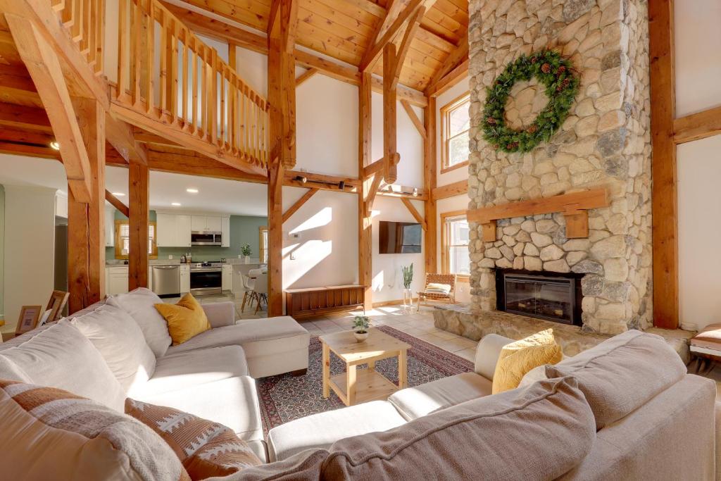 a large living room with a stone fireplace at Waterfront Lakes Region Home on Private Cove! in Alton Bay