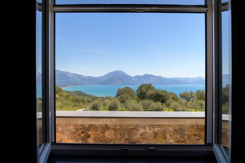 a window with a view of the water and mountains at L'Incanto del Golfo li cylentos in Scario