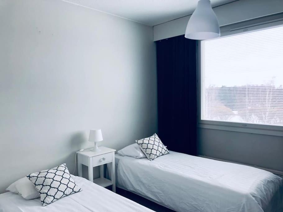 ポリにあるKotimaailma Pori asunto 3 henkilölleのベッド2台と窓のある寝室