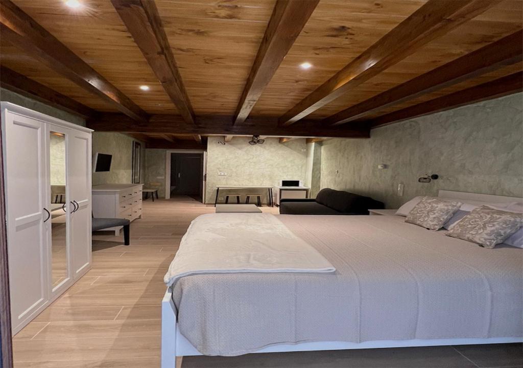 duże łóżko w pokoju z drewnianym sufitem w obiekcie CASA PEQUE w mieście Laguardia