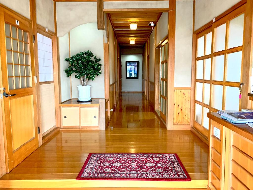 a hallway of a house with a rug on the floor at Guest house En in Fujiyoshida