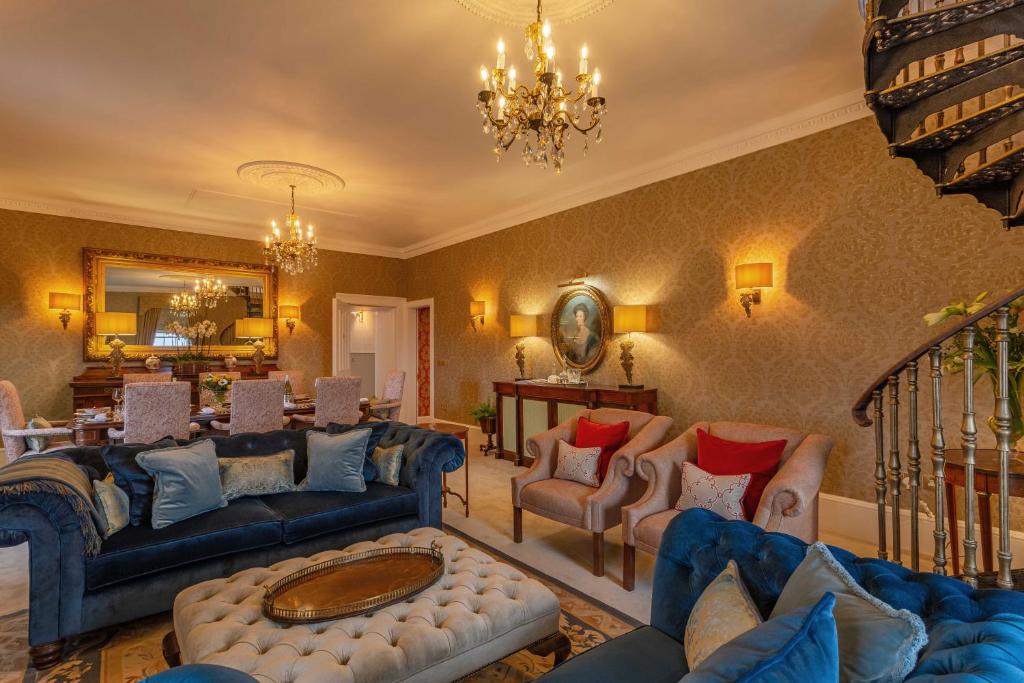 duży salon z niebieskimi kanapami i krzesłami w obiekcie Glenapp Castle w mieście Ballantrae