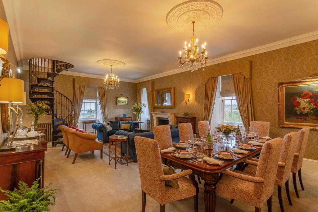 a dining room with a table and a living room at Glenapp Castle in Ballantrae