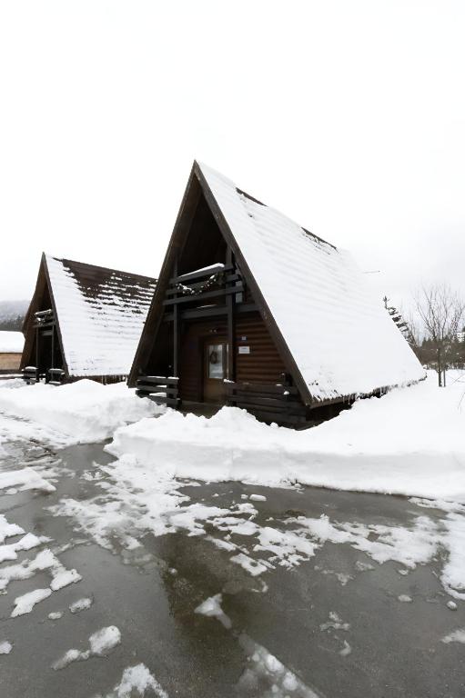 una cabaña cubierta de nieve con mucho hielo en Alpska kuća Klek, en Jasenak