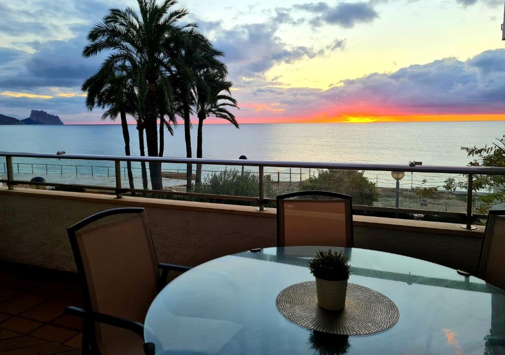 einen Tisch und Stühle auf einem Balkon mit Meerblick in der Unterkunft SUMMER APARTMENT & BEACH ALTEA First line Wifi in Altea