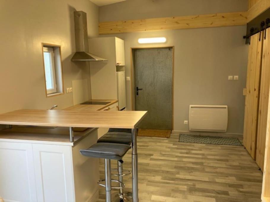 - une cuisine avec un comptoir et des tabourets dans une pièce dans l'établissement Agréable studio proche de Rouen, à Le Grand-Quevilly