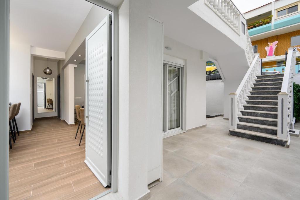 korytarz domu z białymi ścianami i schodami w obiekcie Lux City Apartment w mieście Rodos