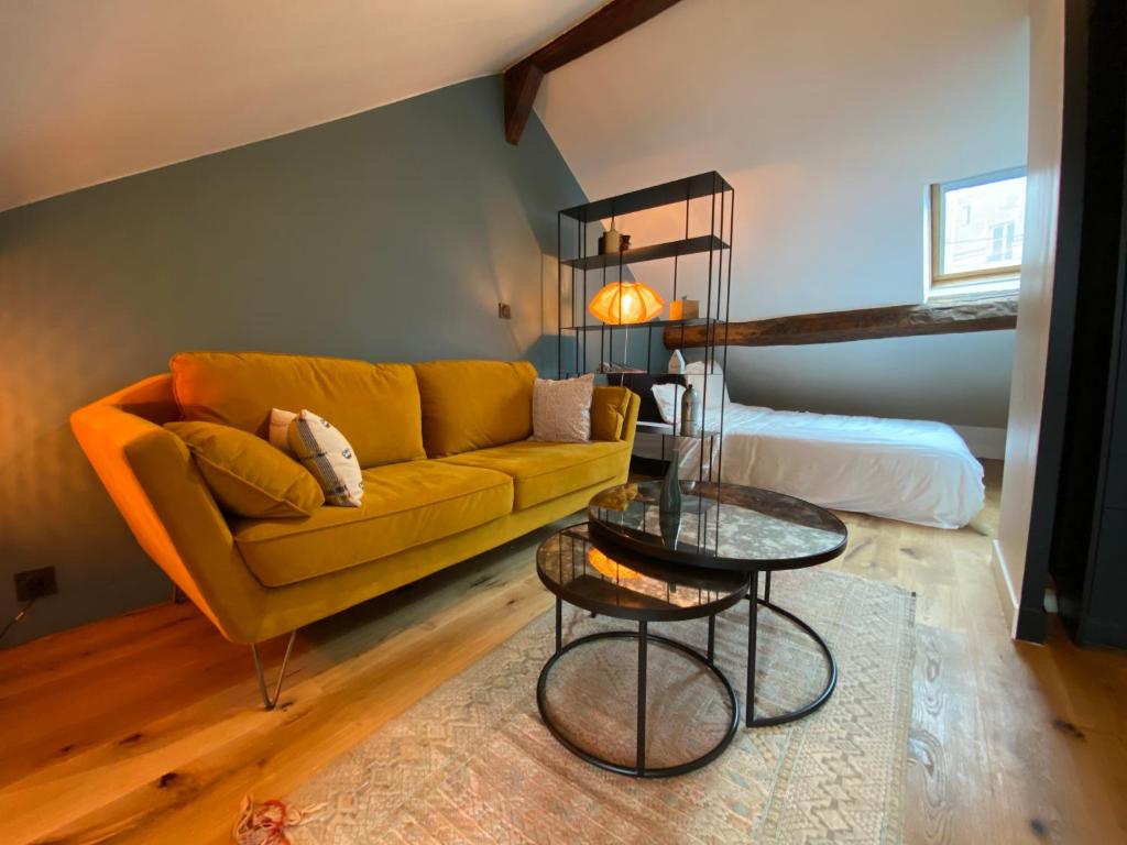 un salon avec un canapé jaune et une table dans l'établissement Le Loft Lepic, à Paris