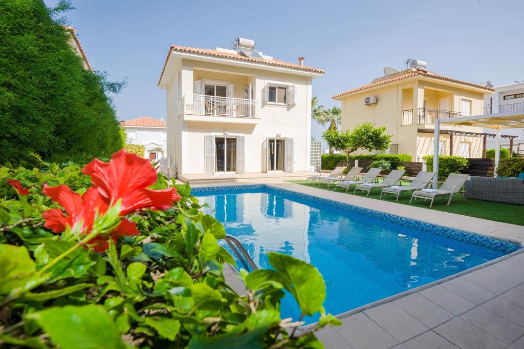 a villa with a swimming pool and a house at Villa Emily in Protaras