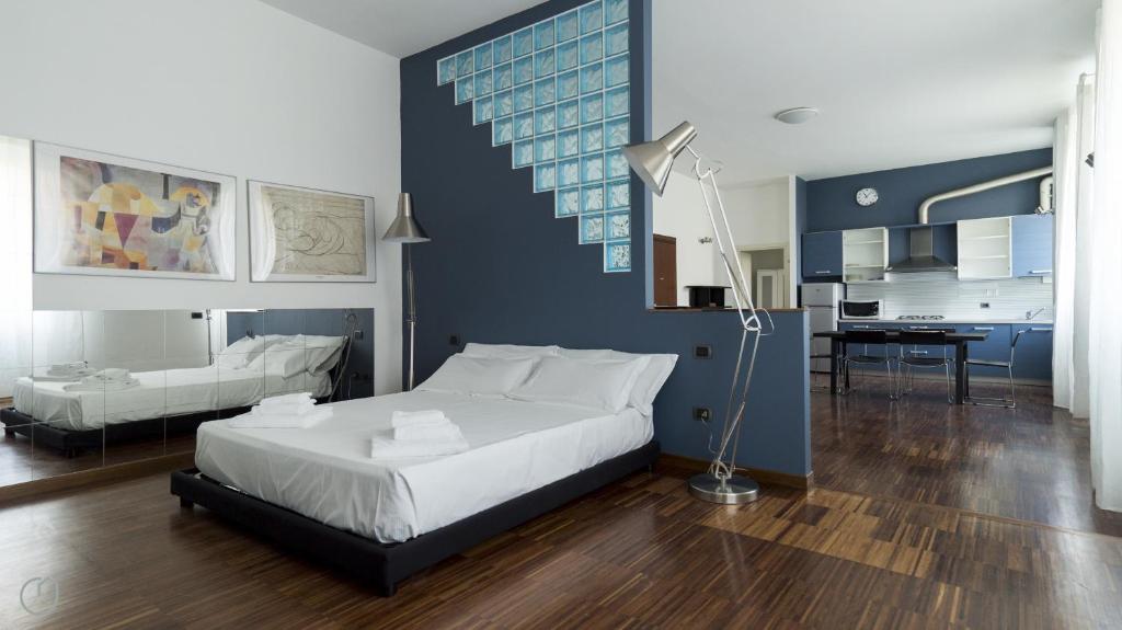 1 dormitorio con cama blanca y pared azul en Italianway-Pastorelli, en Milán