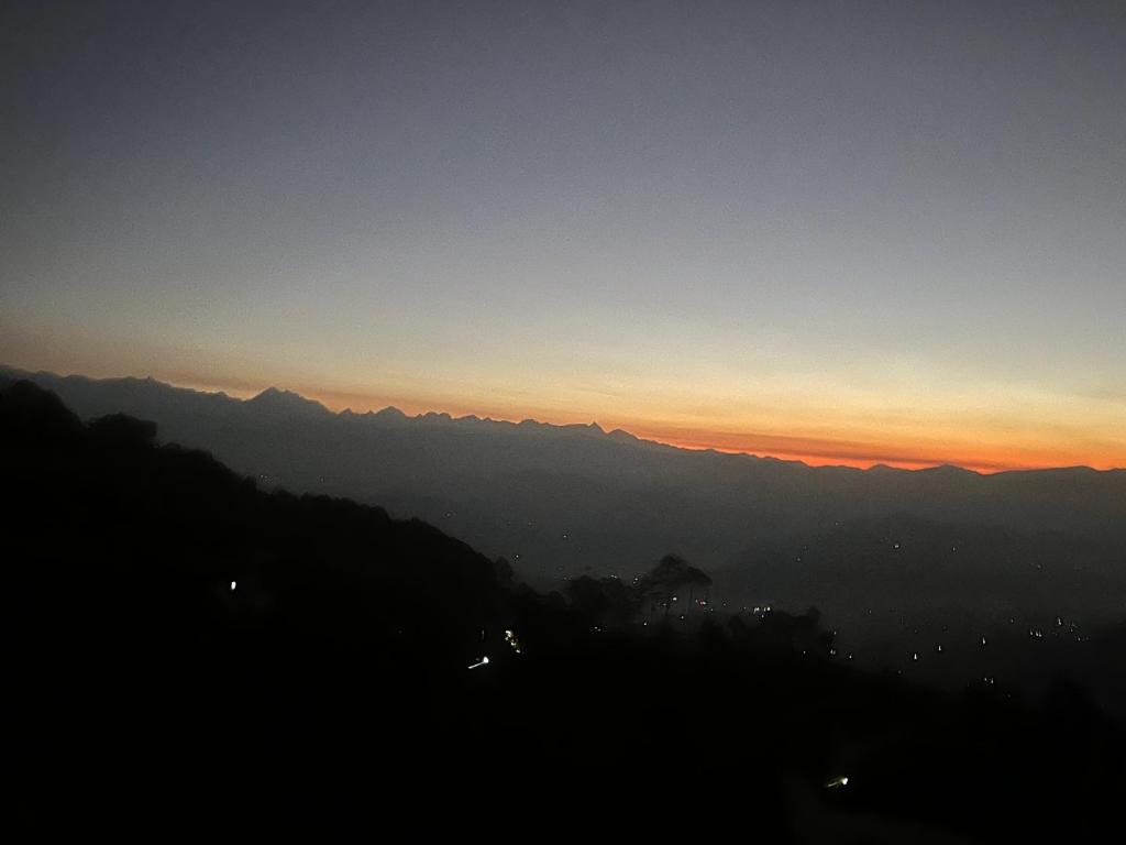 una vista de una puesta de sol con montañas en el fondo en Hotel Nagarkot Holiday Inn en Nagarkot