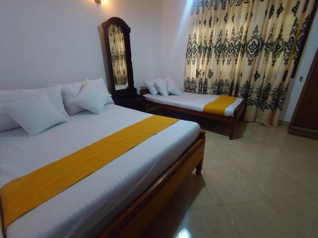 a bedroom with two beds and a mirror and curtains at Escape Ella Bungalow in Bandarawela