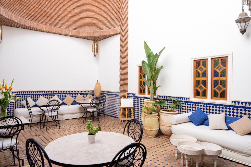 salon z kanapą, stołami i krzesłami w obiekcie Riad Le Marocain w Marakeszu