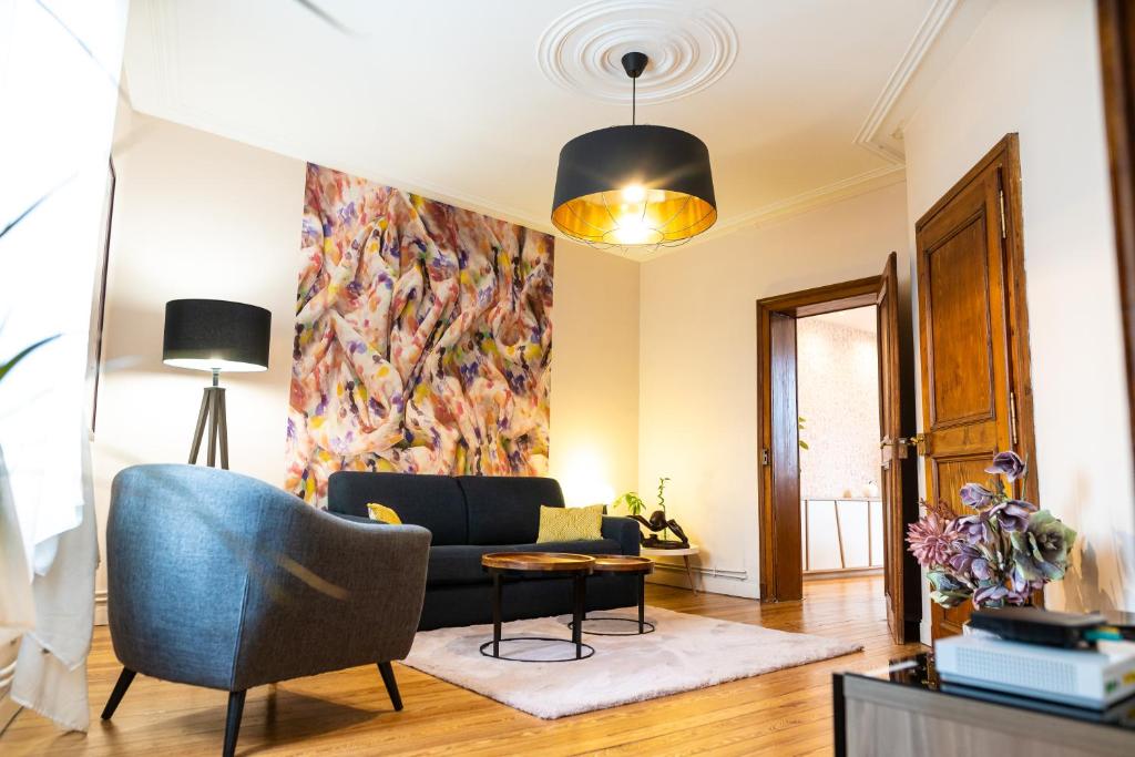 ein Wohnzimmer mit einem Sofa und einem Tisch in der Unterkunft Le Maginot - Superbe Appartement de 75m2 - Position Centrale Centre Ville, Pompidou, Nouvelle Ville - 2 à 4 Personnes - in Metz