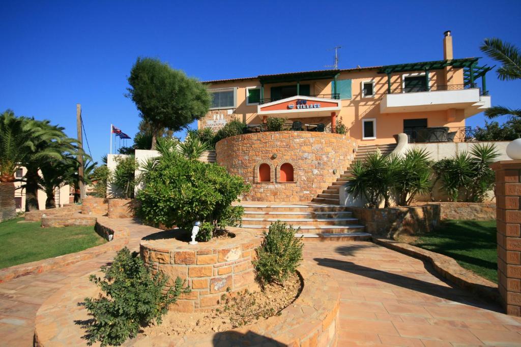 une maison avec un escalier en pierre devant elle dans l'établissement Sun Village Hotel Apartments, à Megás Limniónas