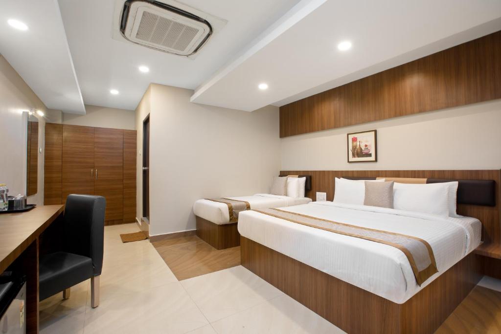 Habitación de hotel con cama y escritorio en Grande Inn Trichy, en Tiruchchirāppalli