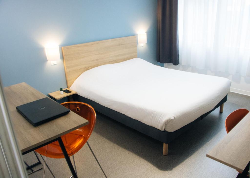 um quarto com uma cama e uma secretária com um computador portátil em Twenty Business Flats Maisons Alfort Les Juilliottes em Maisons-Alfort