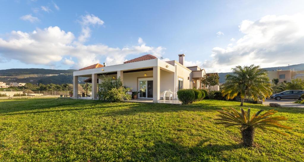 a house with a green lawn in front of it at Alegria 3bd Villa in Kos