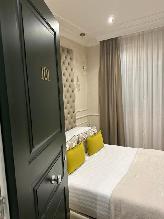 sypialnia z łóżkiem z 2 żółtymi poduszkami w obiekcie NLM Boutique Suites w Rzymie