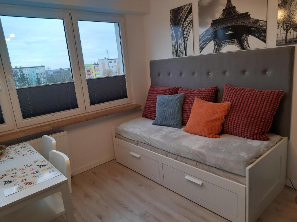 um banco com almofadas num quarto com janelas em Family Suite Świecie em Swiecie