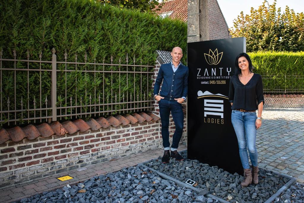 a man and a woman standing next to a sign at SN Logies in Tremelo