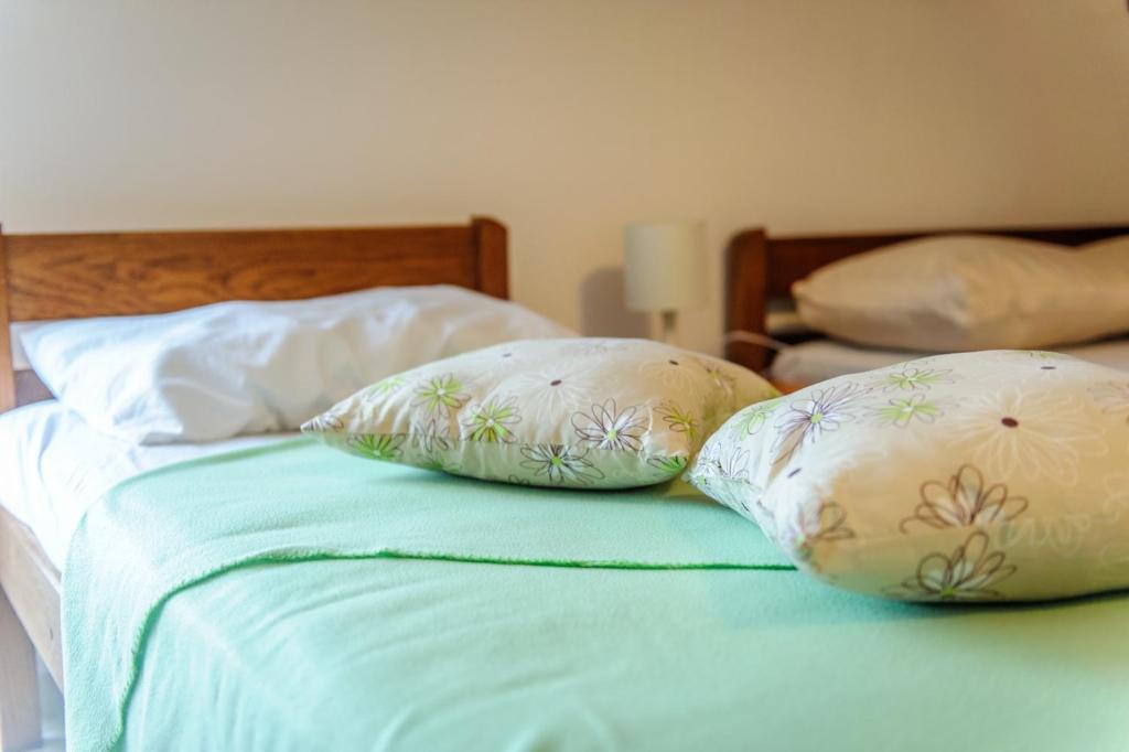 two pillows sitting on top of a bed at Apartments & rooms Lucie in Posedarje