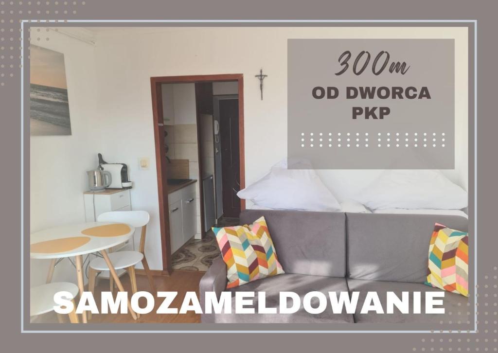 Cartel de un dormitorio con cama y mesa en "Przy dworcu PKP", en Kołobrzeg