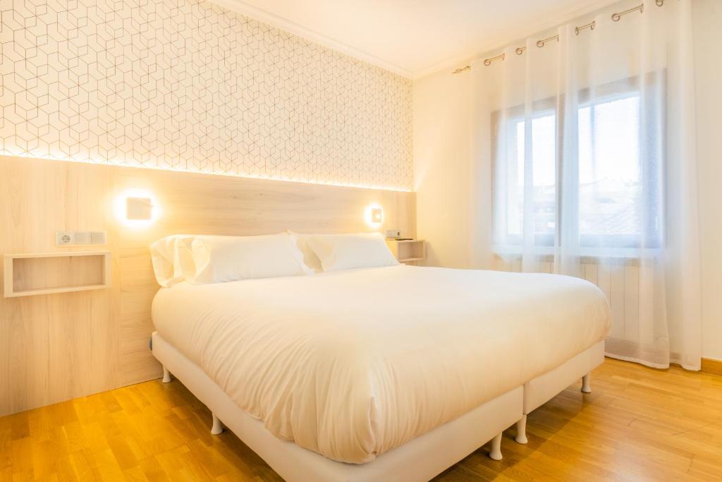 ピエドライタにあるHostal Gran Duqueの窓付きの客室で、白い大型ベッド1台が備わります。