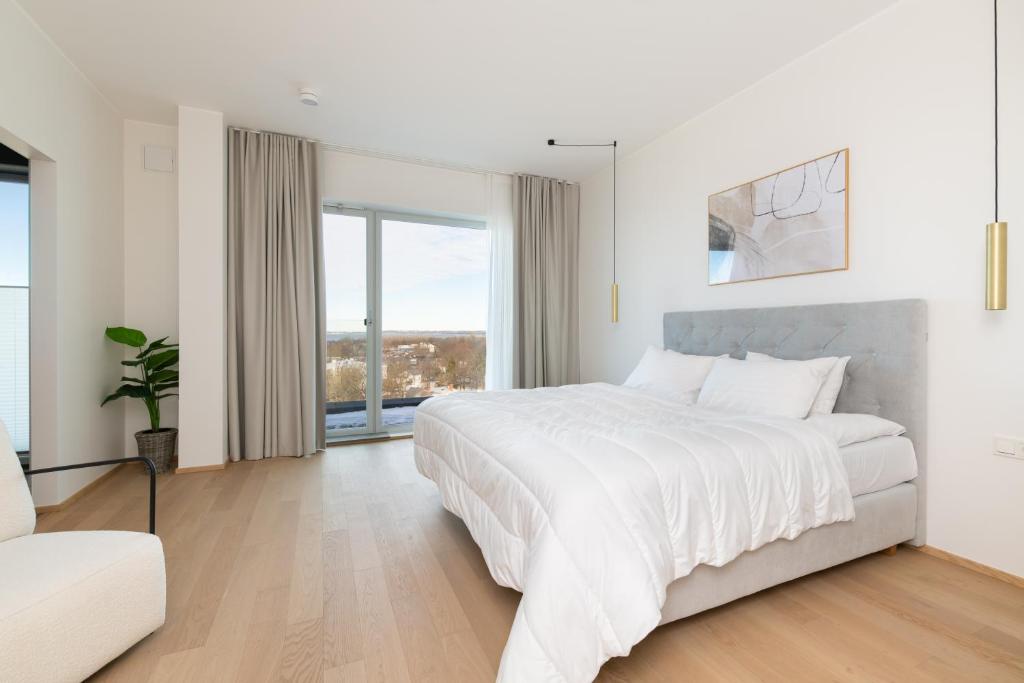 a white bedroom with a large bed and a couch at 4bdr Modern and Stylish Apartment near Kadriorg with Free Parking in Tallinn