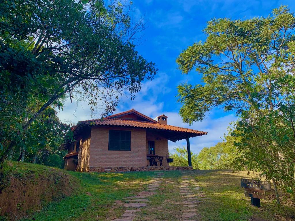 une petite maison sur une colline avec un chemin de terre dans l'établissement August de Saint Hilaire/ Reserva Alto da Colina, à Conceição da Ibitipoca