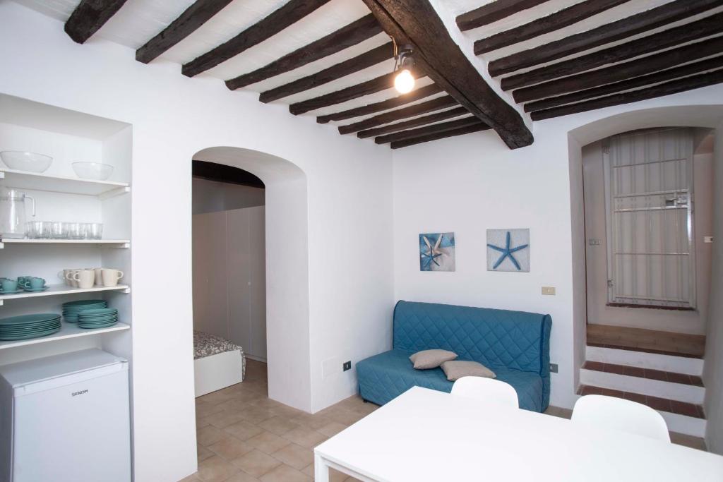 un soggiorno con pareti bianche e un divano blu di A Casa di Peter Pan a Capoliveri