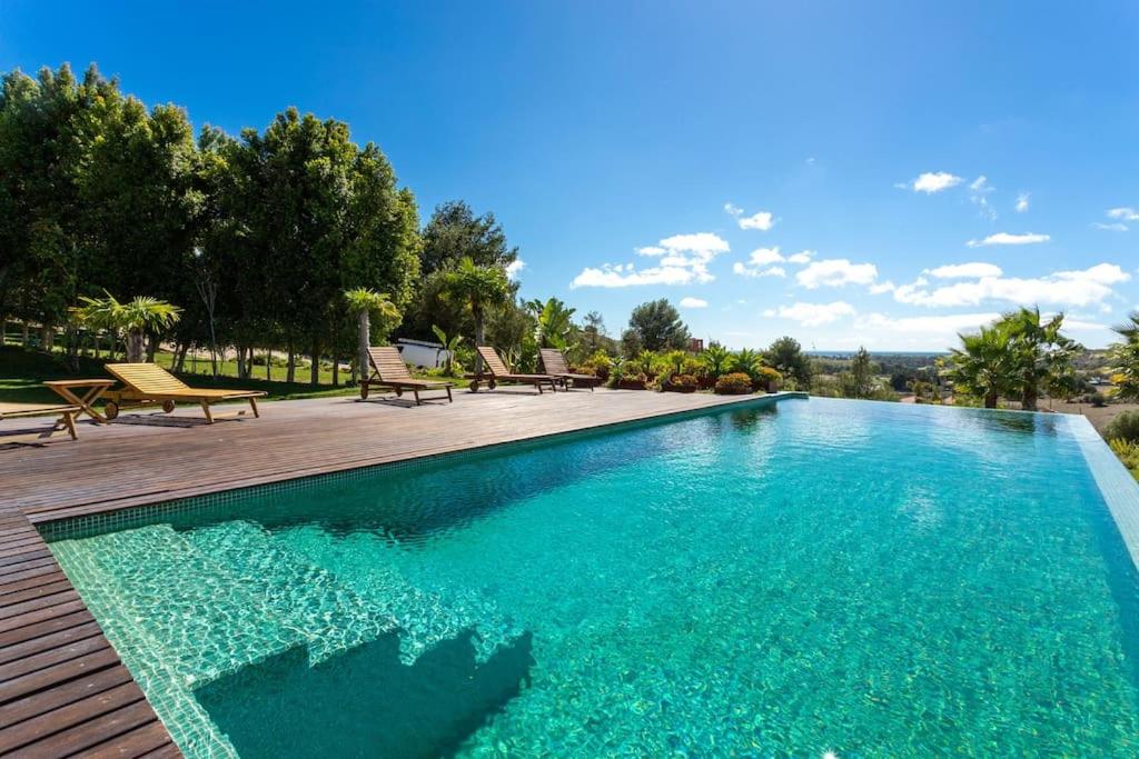 a swimming pool with blue water on a wooden deck at Wonderful Villa near Lisbon in São Domingos de Rana