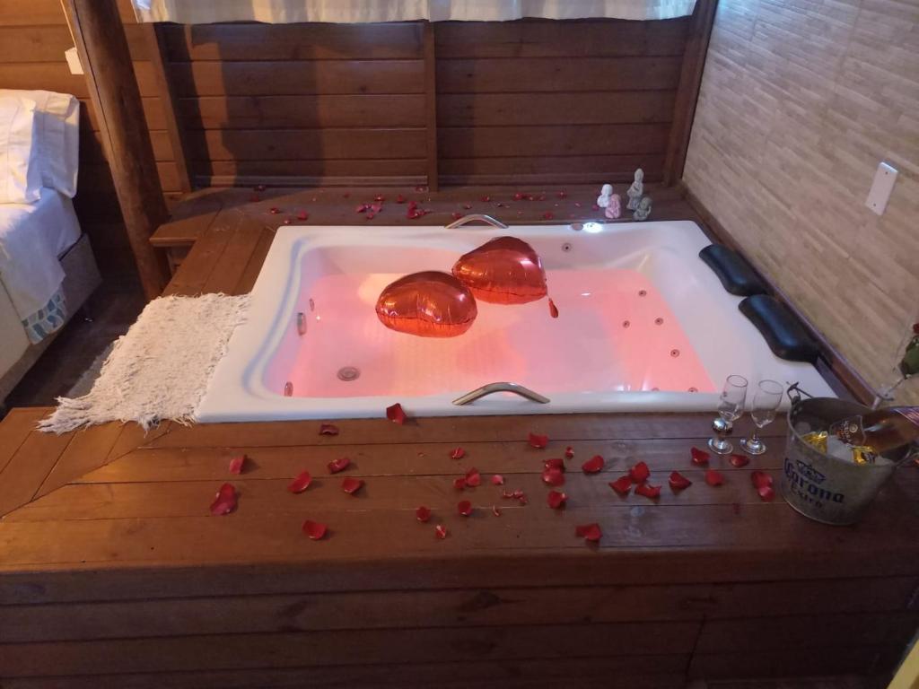 a bath tub filled with red peppers in a room at pimenta rosa guesthouse in Praia do Rosa