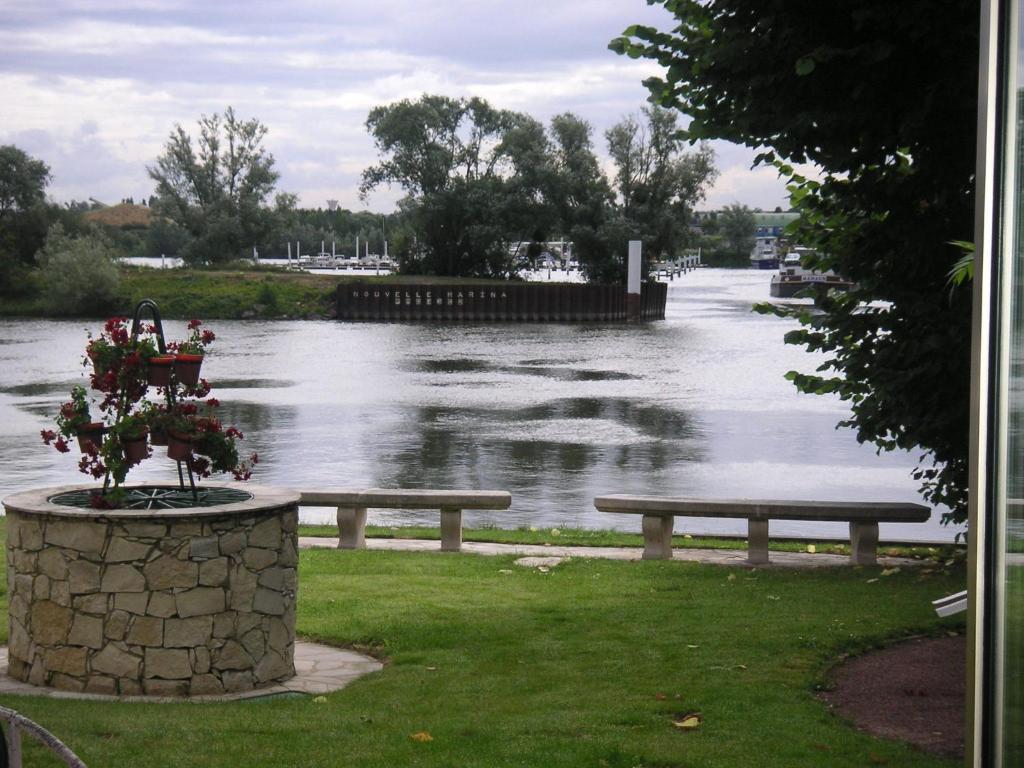 a picnic table and bench next to a body of water at Ilvil in Villennes-sur-Seine