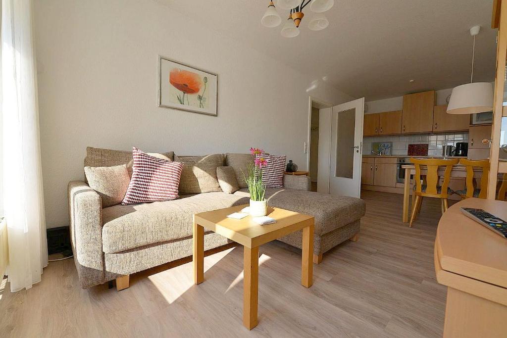 uma sala de estar com um sofá e uma mesa em Haus Nordseebrandung ND24 em Cuxhaven