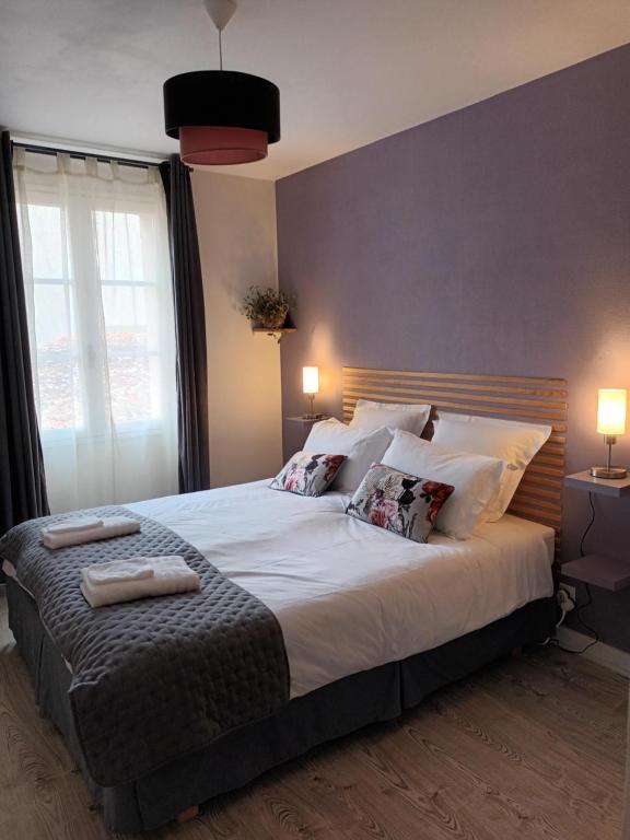 a bedroom with a large bed with two towels on it at Les chambres de la Vallée in Argenton-Château