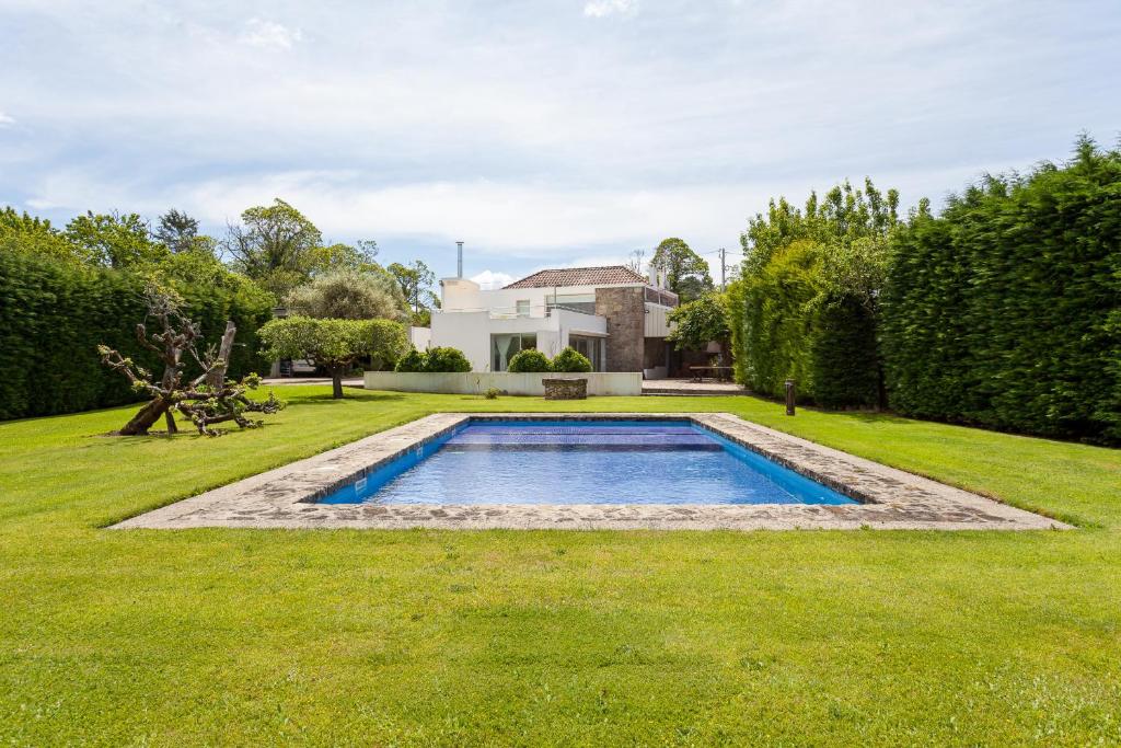 a swimming pool in the middle of a yard at Sé Apartamentos - Casa da Rabeta in Forjãis